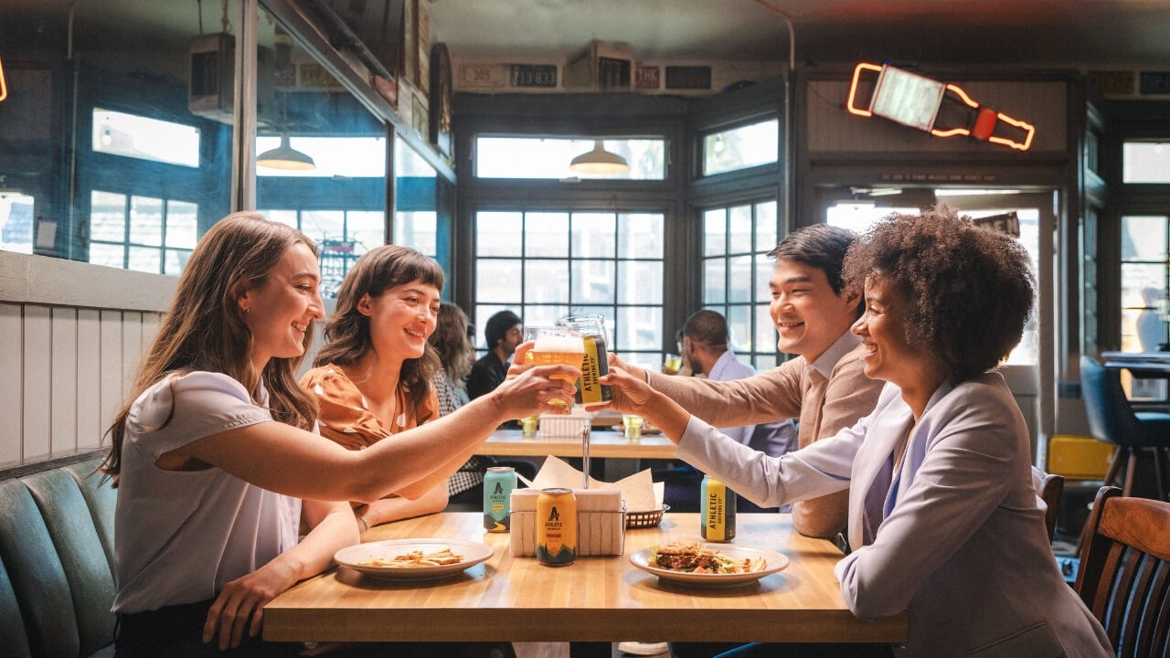 a group of people sitting at a table clinking glasses