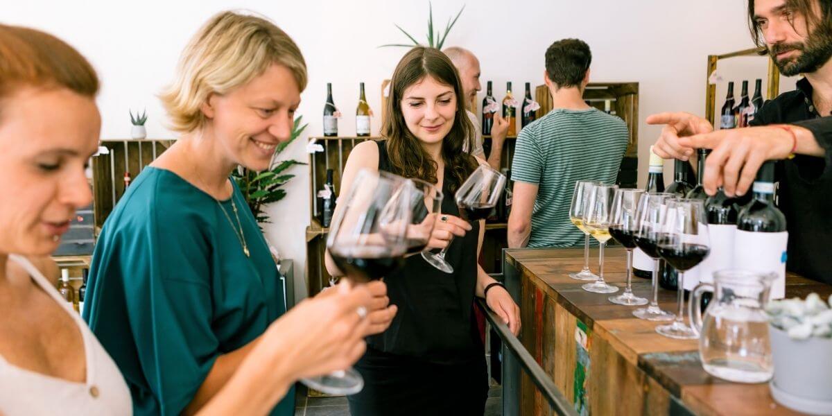 a group of women holding wine glasses at a wine tasting 