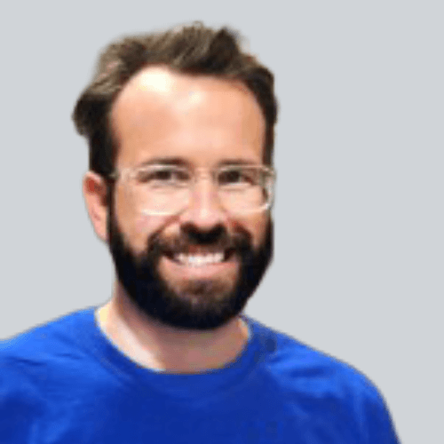 A photo of a man smiling in a blue shirt