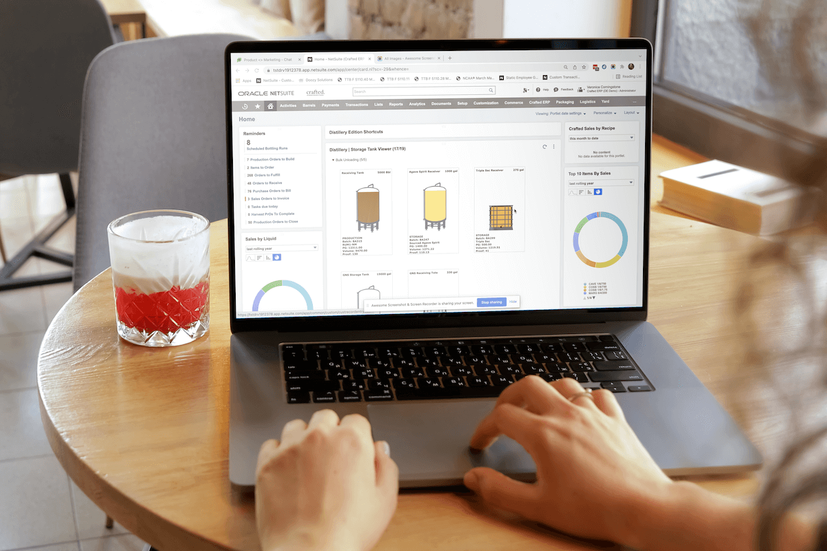 A photo of a woman working on a laptop on specialized beverage ERP built for IT leaders