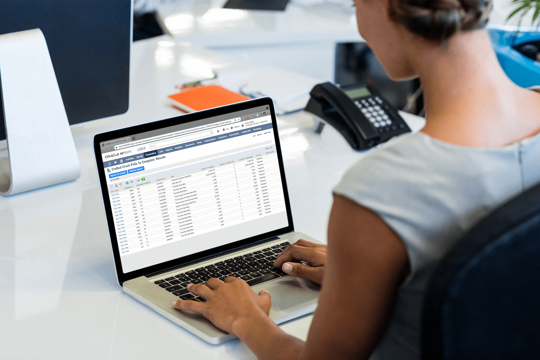 A photo of a woman working in beverage ERP with AI-ready data