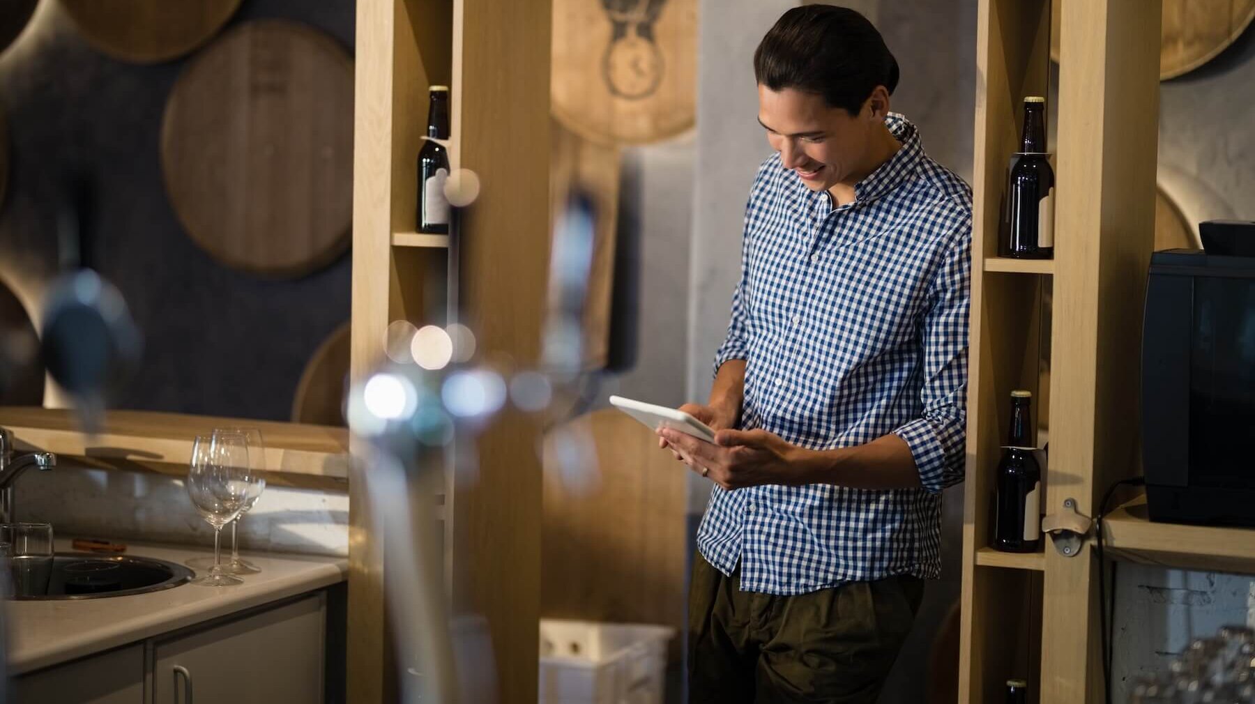 A photo of a winemaker using winery ERP software on a tablet at a winery