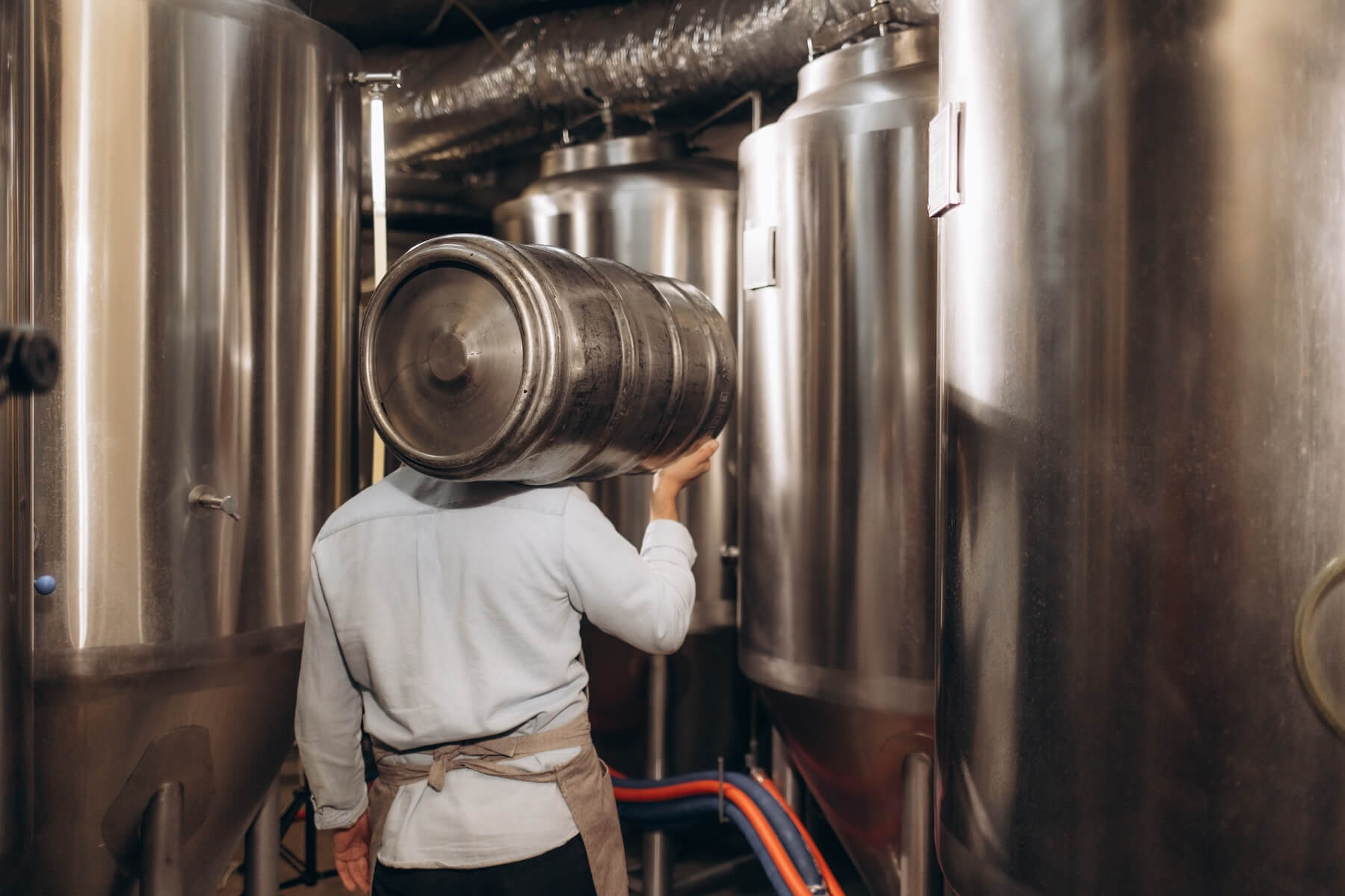 Portrait of male brewer carrying a keg on his shoulder. His brewery is struggling with accurate brewery demand forecasting and is in need of an ERP system.