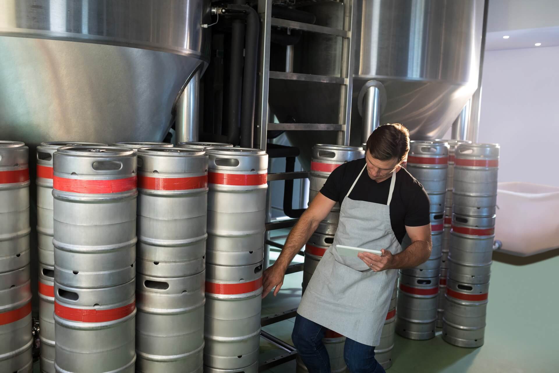 A photo of a brewery employee taking inventory of kegs