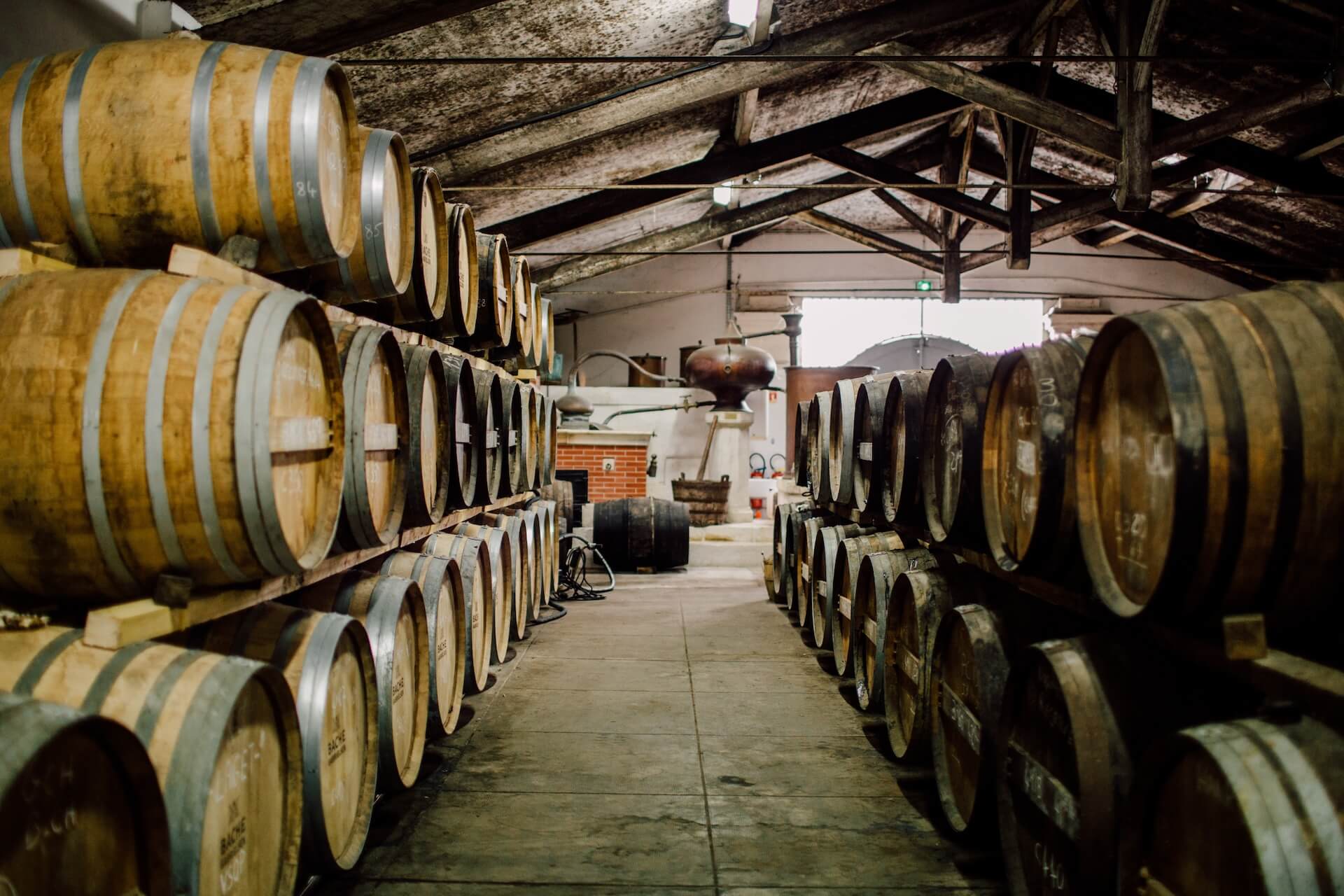 Rows of aging spirits barrels in a warehouse as part of a distillery barrel management program