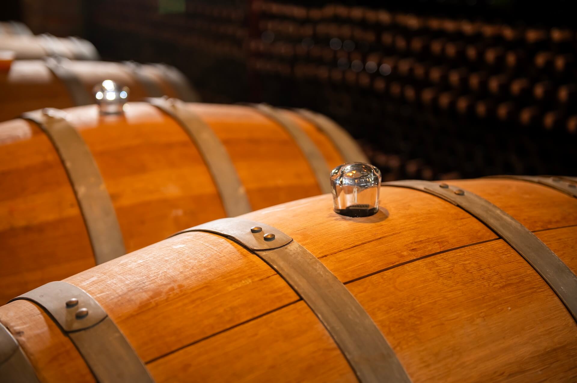 Old wooden wine barrels stacked in a cellar in order